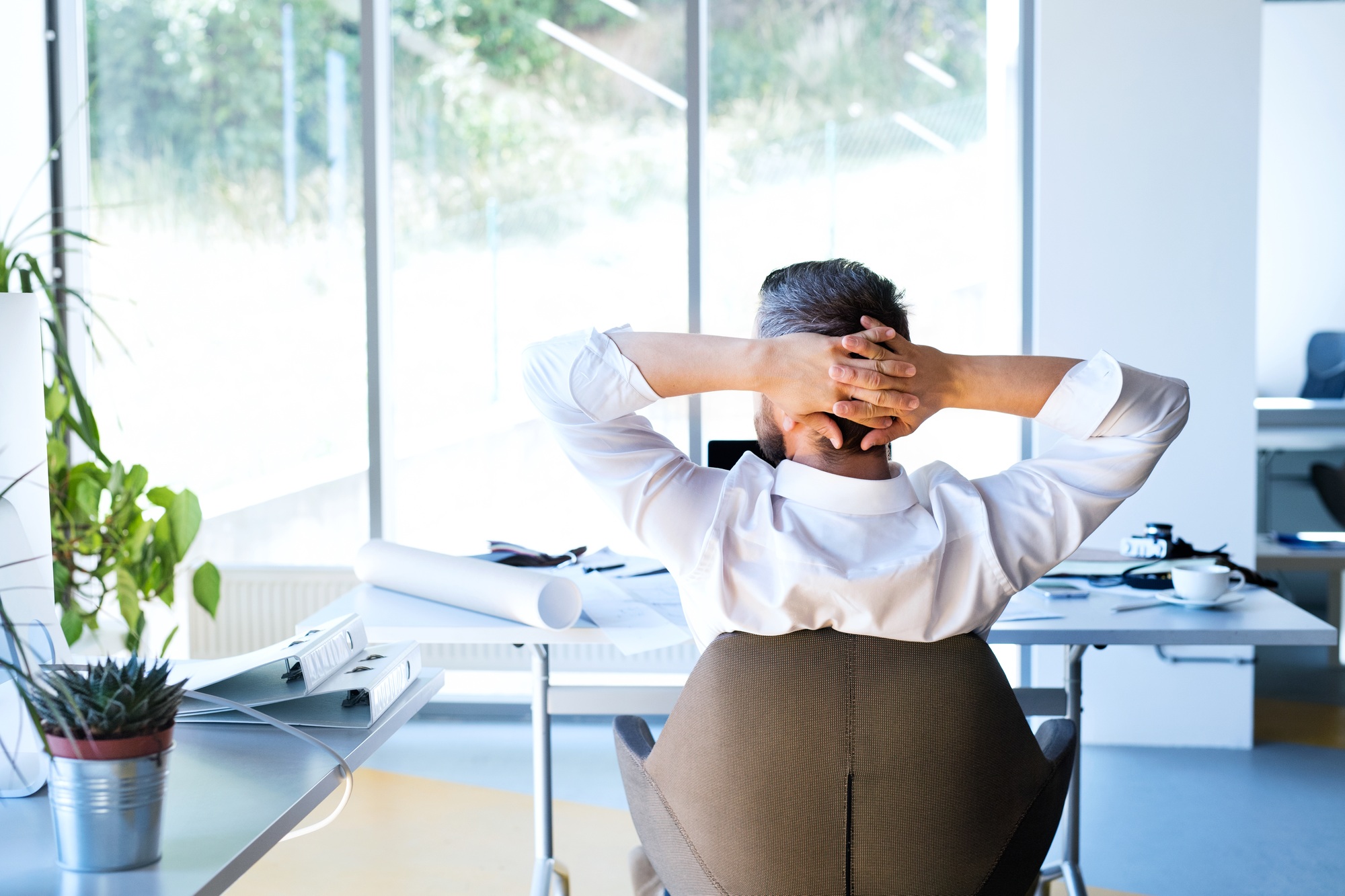 Businessman at the desk in his office resting.