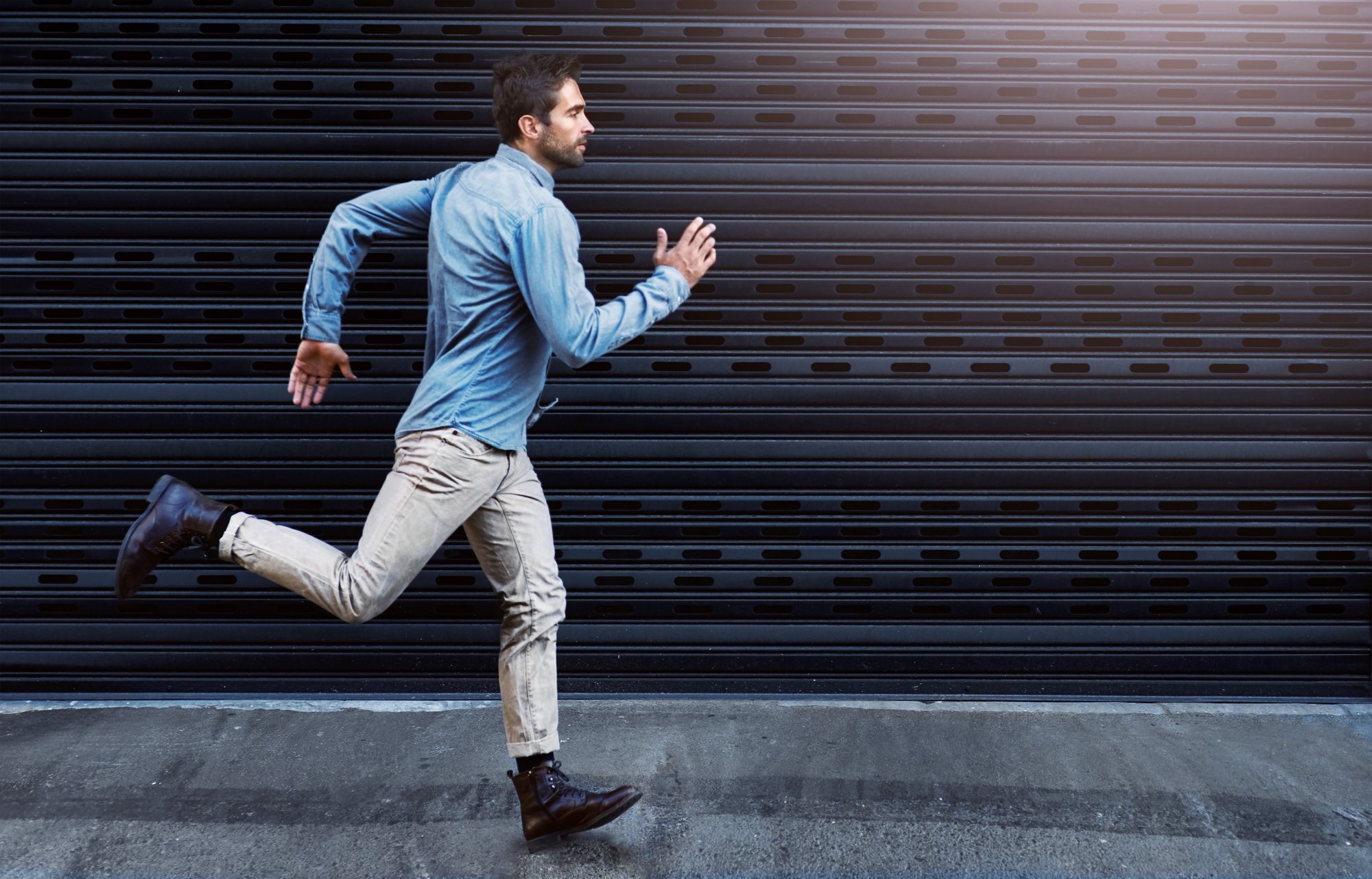 Chase after your dreams. Shot of a handsome young man running in the city.