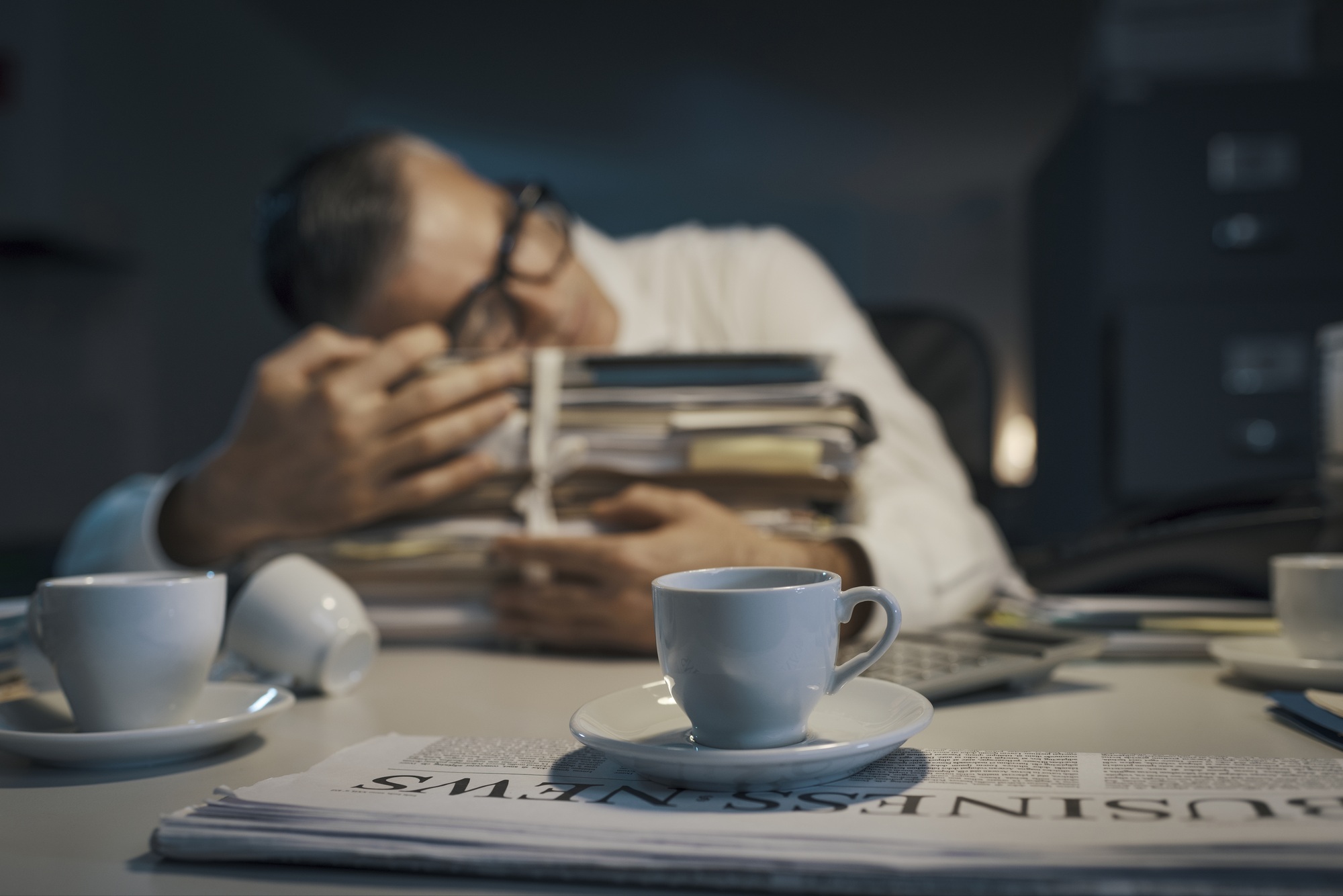 Stressed office worker sleeping at his desk